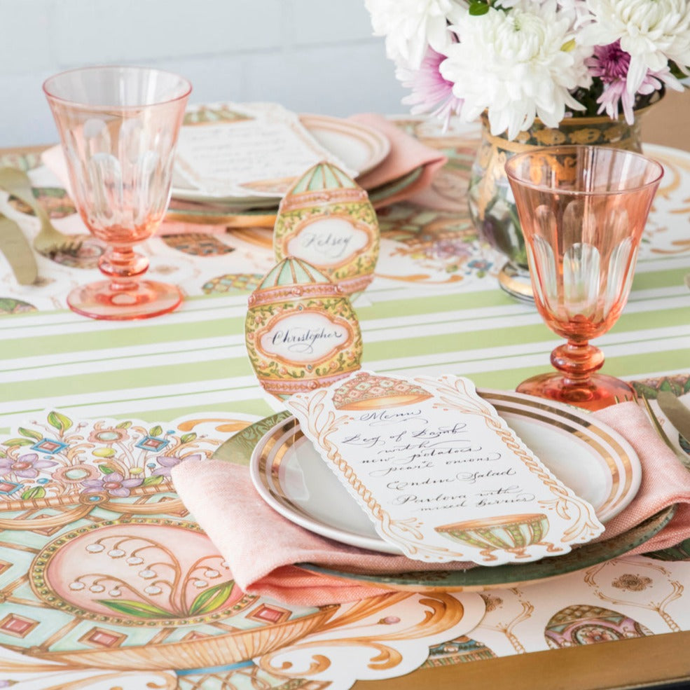 An Easter table setting with pink and white plates and napkins, perfect for labeling dishes or providing a designated writing space, featuring the Hester &amp; Cook Exquisite Egg Place Card.