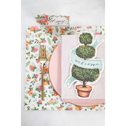 A pink place setting with a potted plant on it, adorned with a Hester &amp; Cook Topiary Table Accent.
