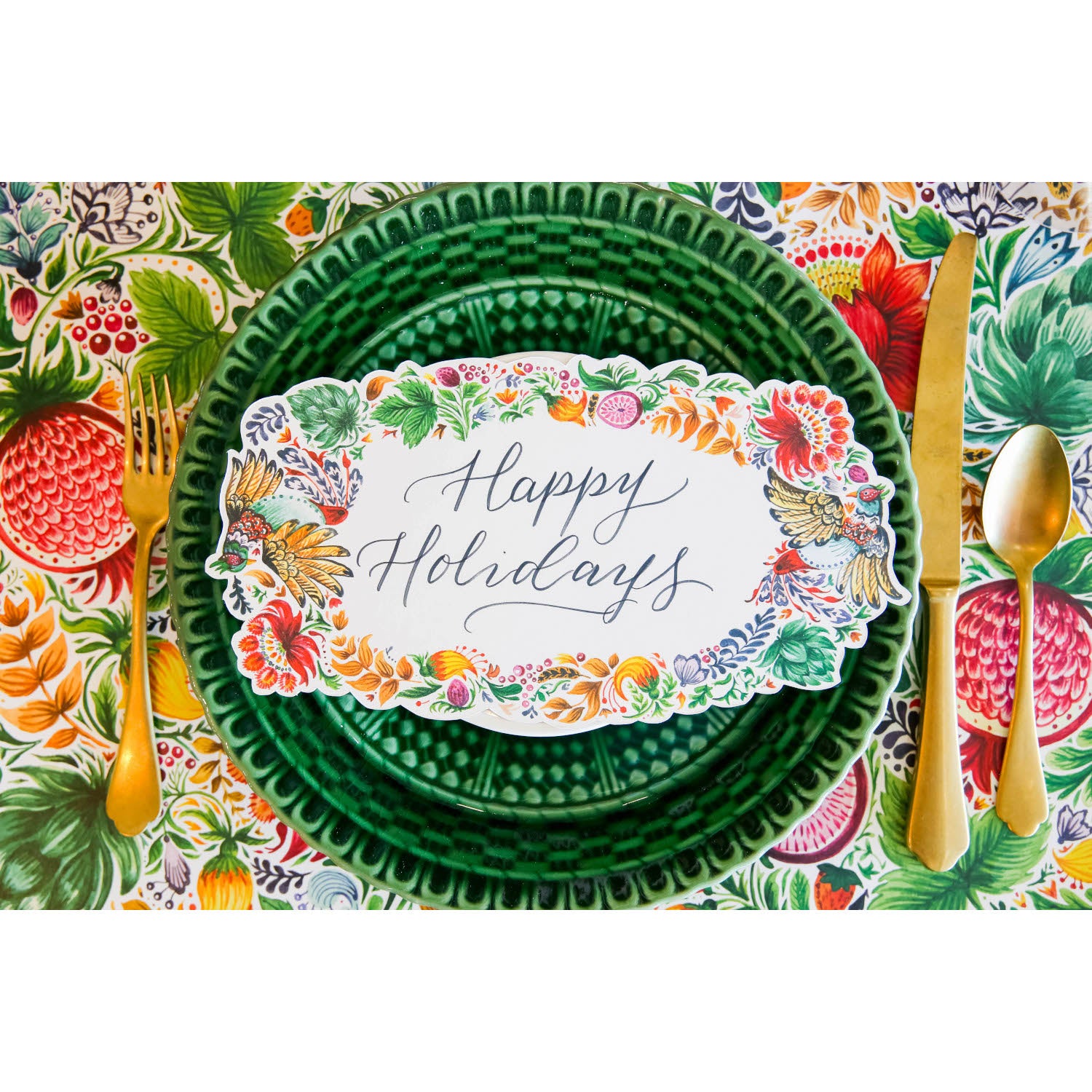 A vibrant place setting featuring a Bountiful Frame Table Accent reading &quot;Happy Holidays&quot; adorning the plate, from above.