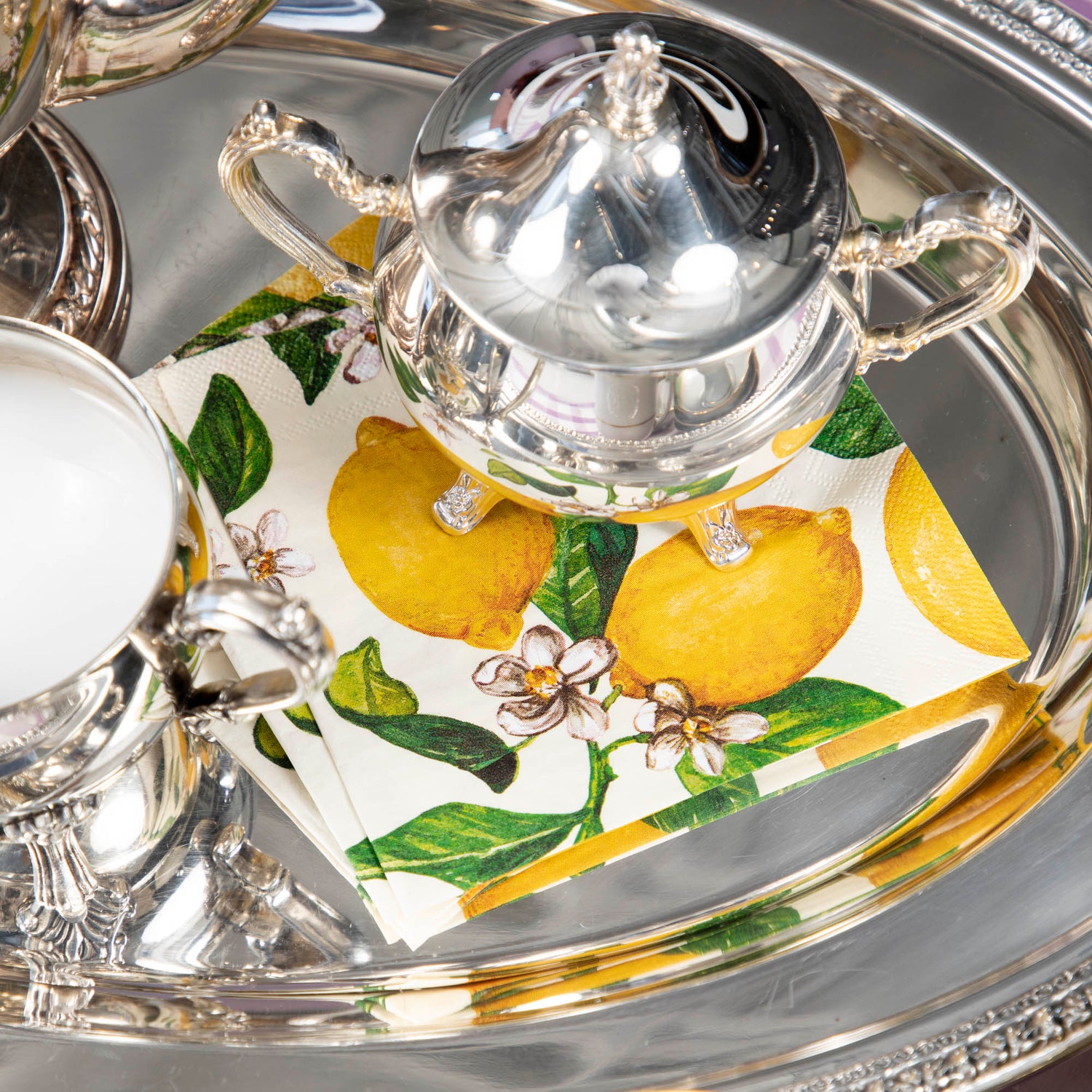A silver tray with Hester &amp; Cook Lemons Napkins on it, adding a pop of color to any occasion.