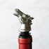 A stainless steel Menagerie Horse Pourer with a horse head design atop a red bottle.