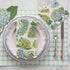 Top-down view of an elegant place setting featuring a Hydrangea Guest Napkin centered on the plate, and a Hydrangea Cocktail Napkin under the glass.