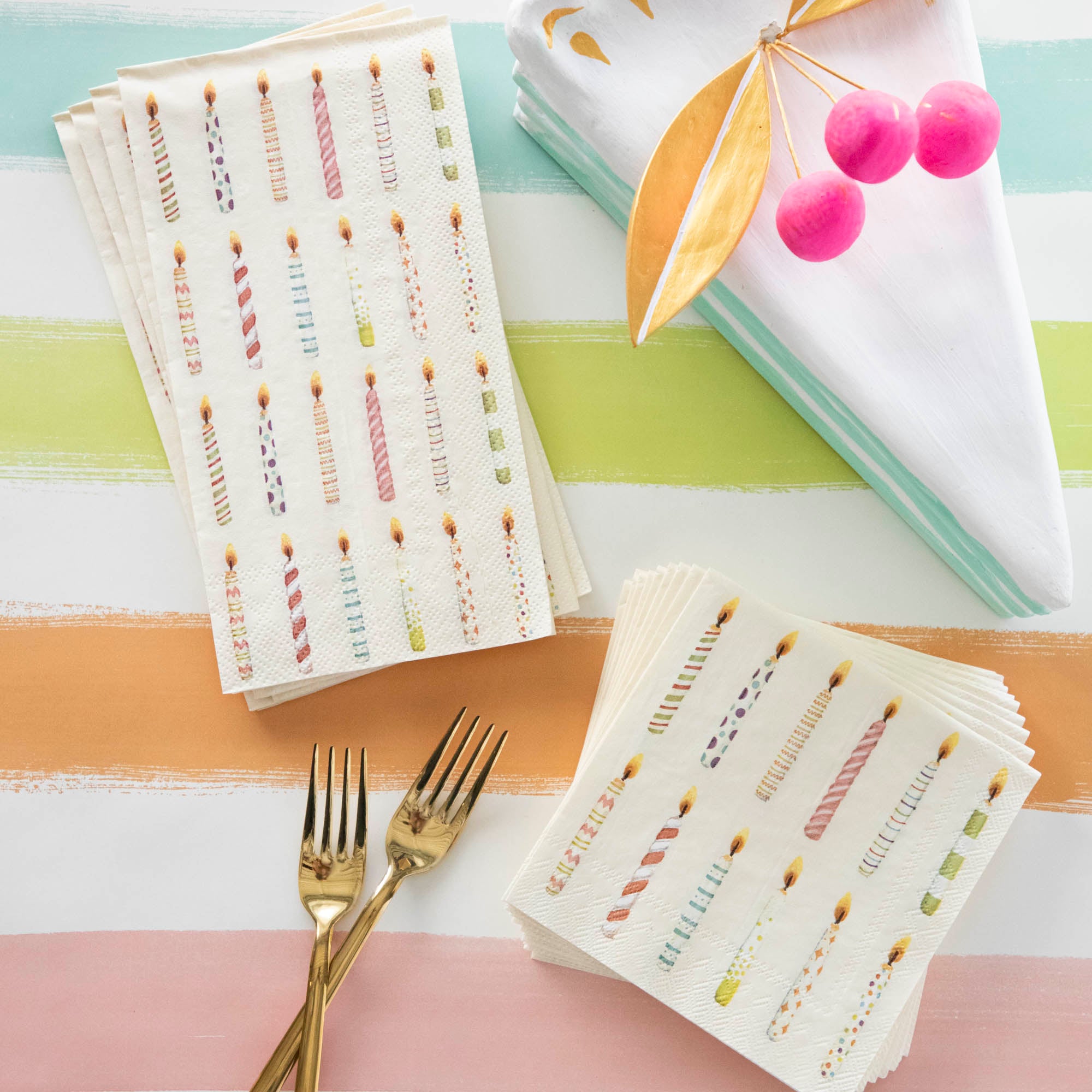 A colorful set of Hester &amp; Cook Birthday Candles Napkins featuring festive stripes.