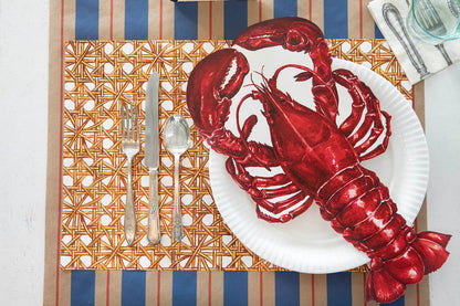 The Die-cut Lobster Placemat resting on the plate in an elegant place setting, from above.