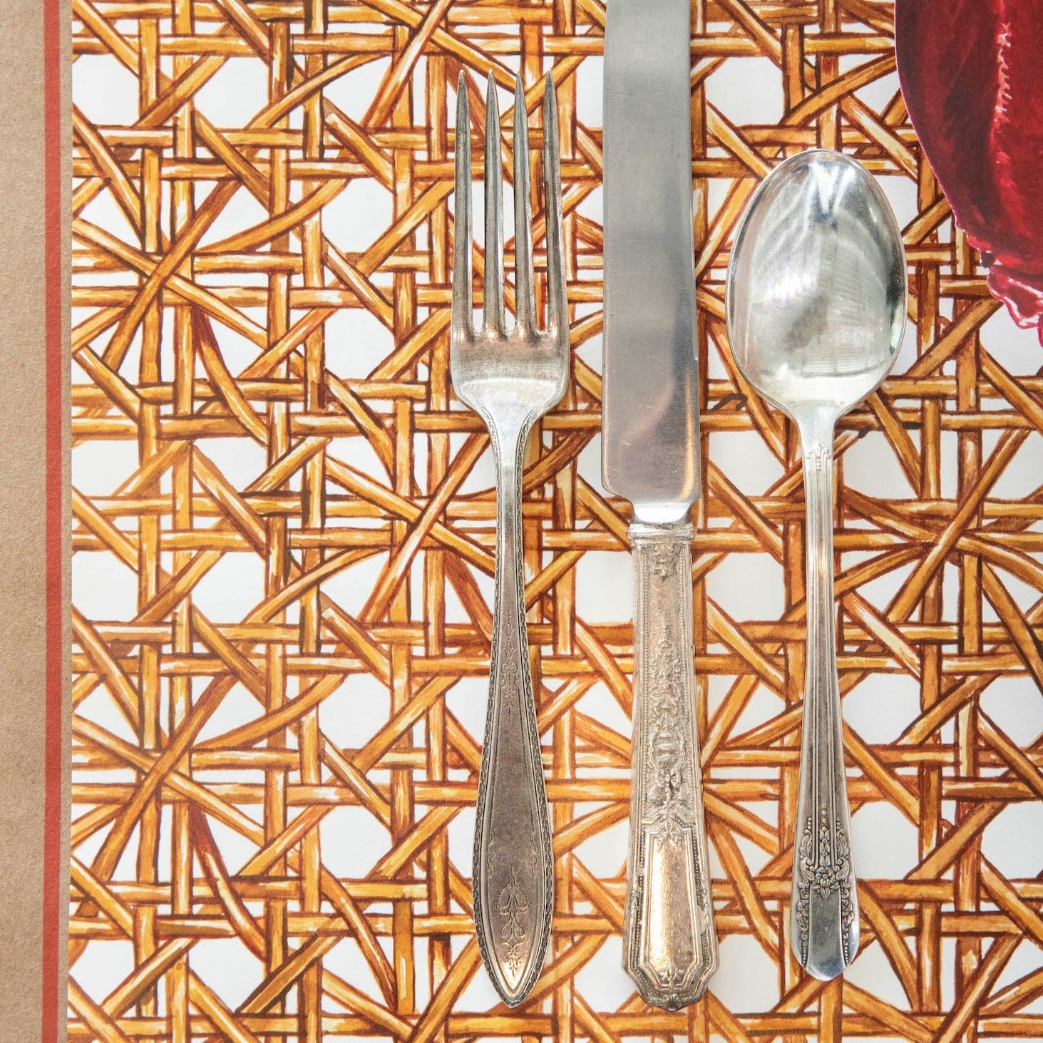 A table setting with a Hester &amp; Cook Rattan Weave Placemat and a knife.