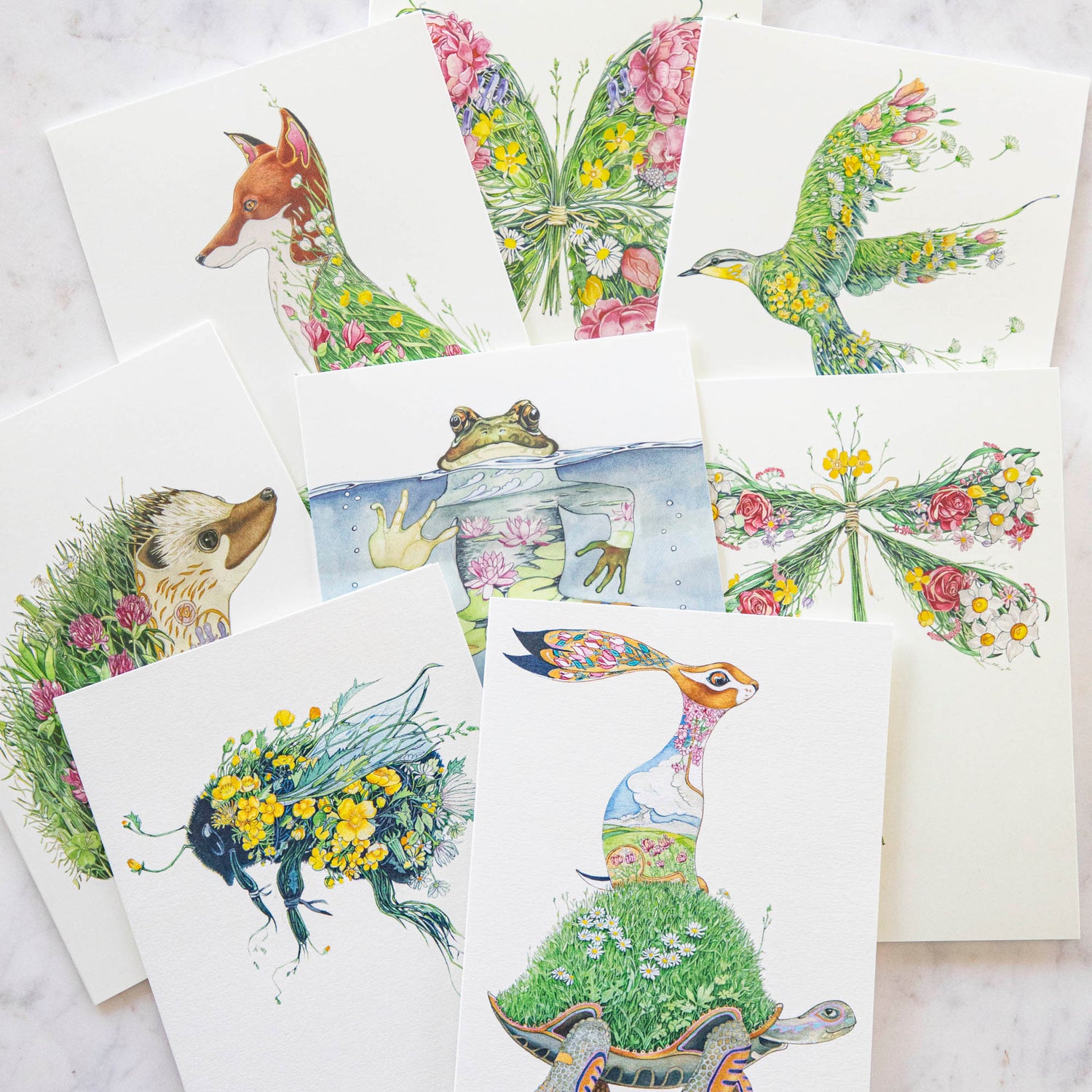 An artistically designed set of Dragonfly Cards featuring intricate watercolor paintings of various animals and flowers by The DM Collection.