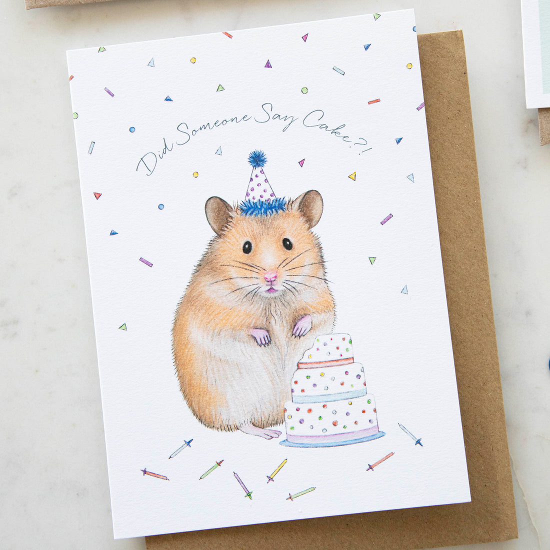 Celebrate with a Lottie Murphy Hamster &amp; Cake Birthday Card featuring an adorable furry friend holding a delicious cake. Share your heartfelt birthday wishes with this charming cake card.