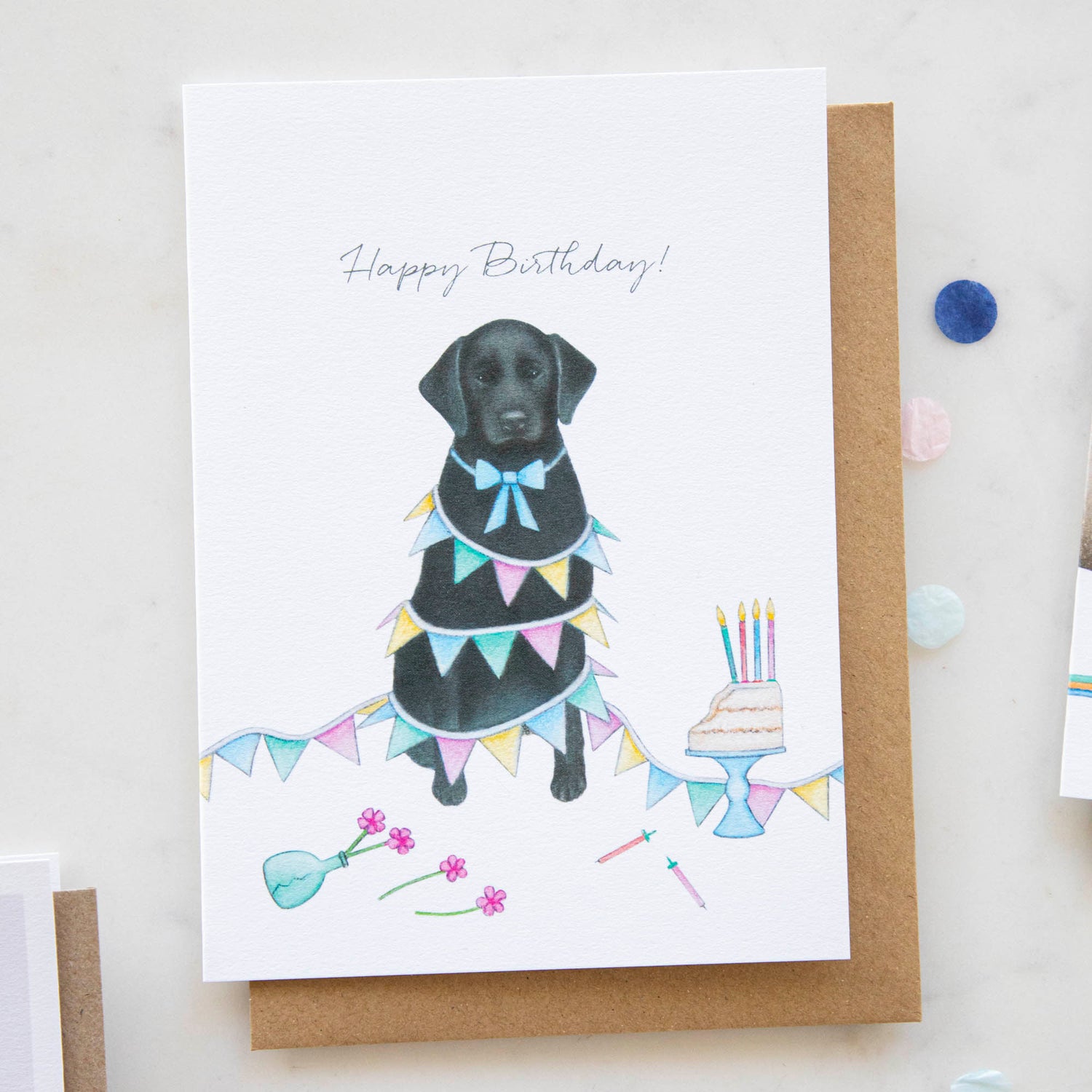 A black Labrador and Bunting birthday card with a birthday cake by Lottie Murphy.