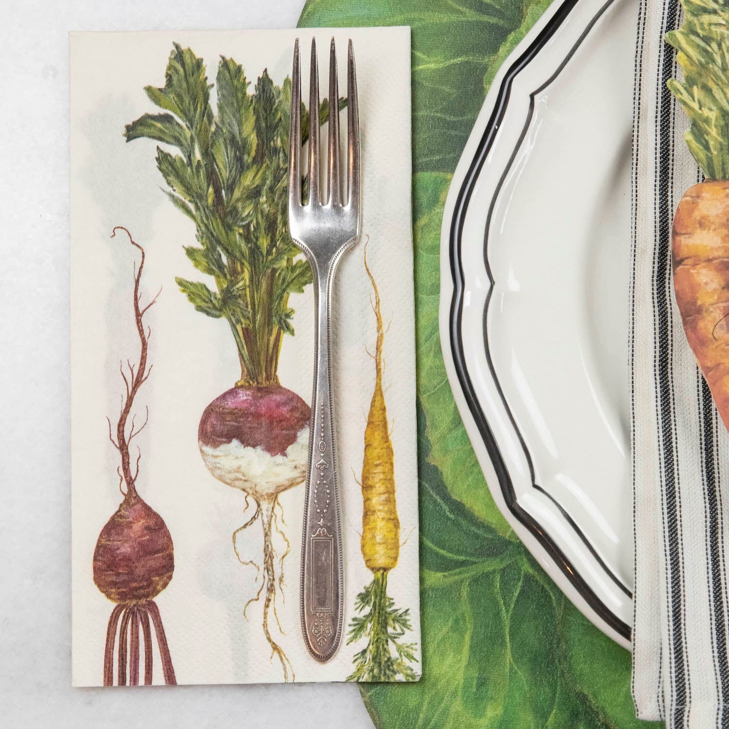 A Farmers' Market Guest Napkin with a fork on it, next to a rustic place setting.