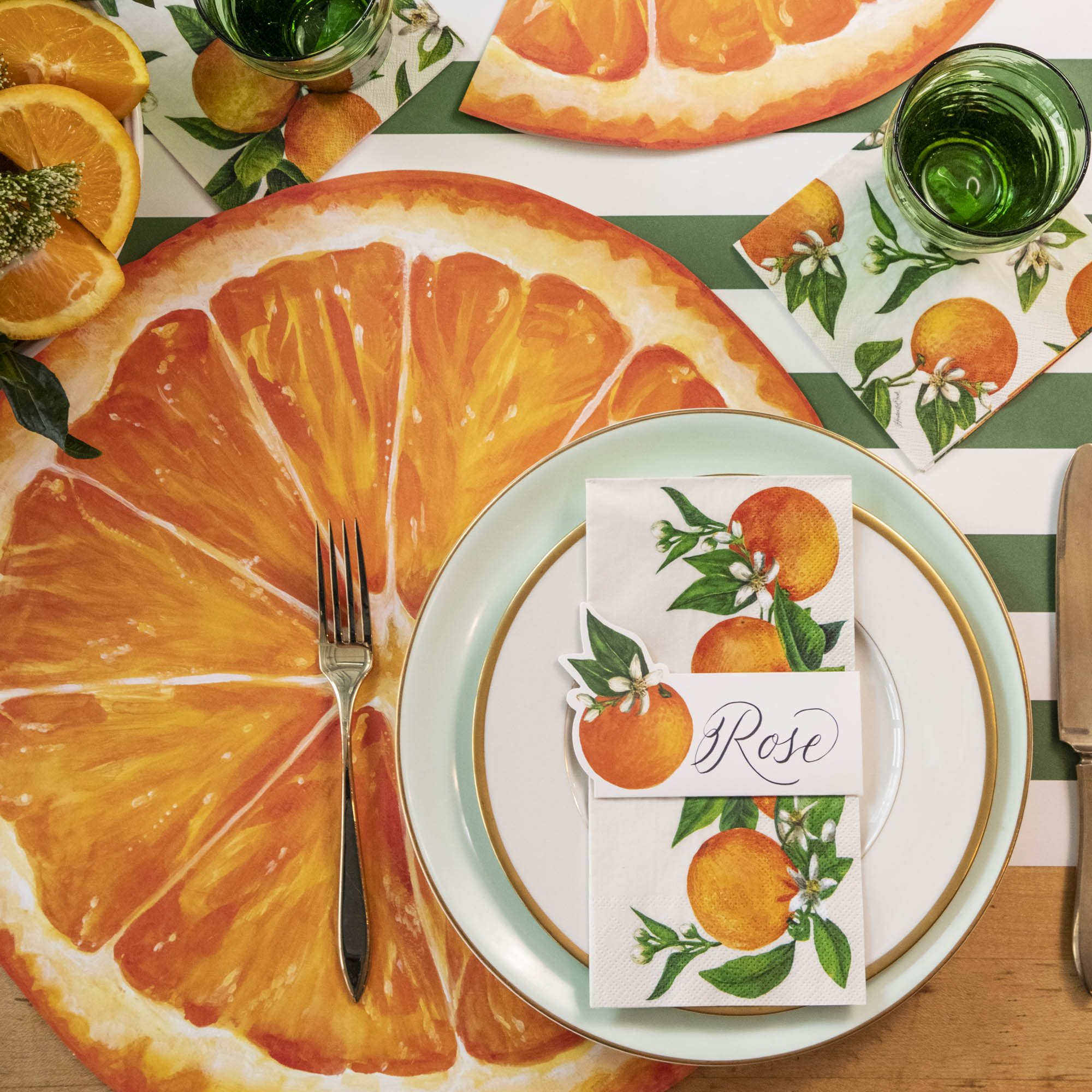 The Die-cut Orange Slice Placemat under an elegant citrus-themed place setting, from above.