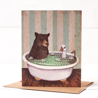 A whimsical Bathtime Card by Hester &amp; Cook featuring an original artwork by Elizabeth Foster, illustrating a bear and a bird taking a bath together in a claw-foot tub.