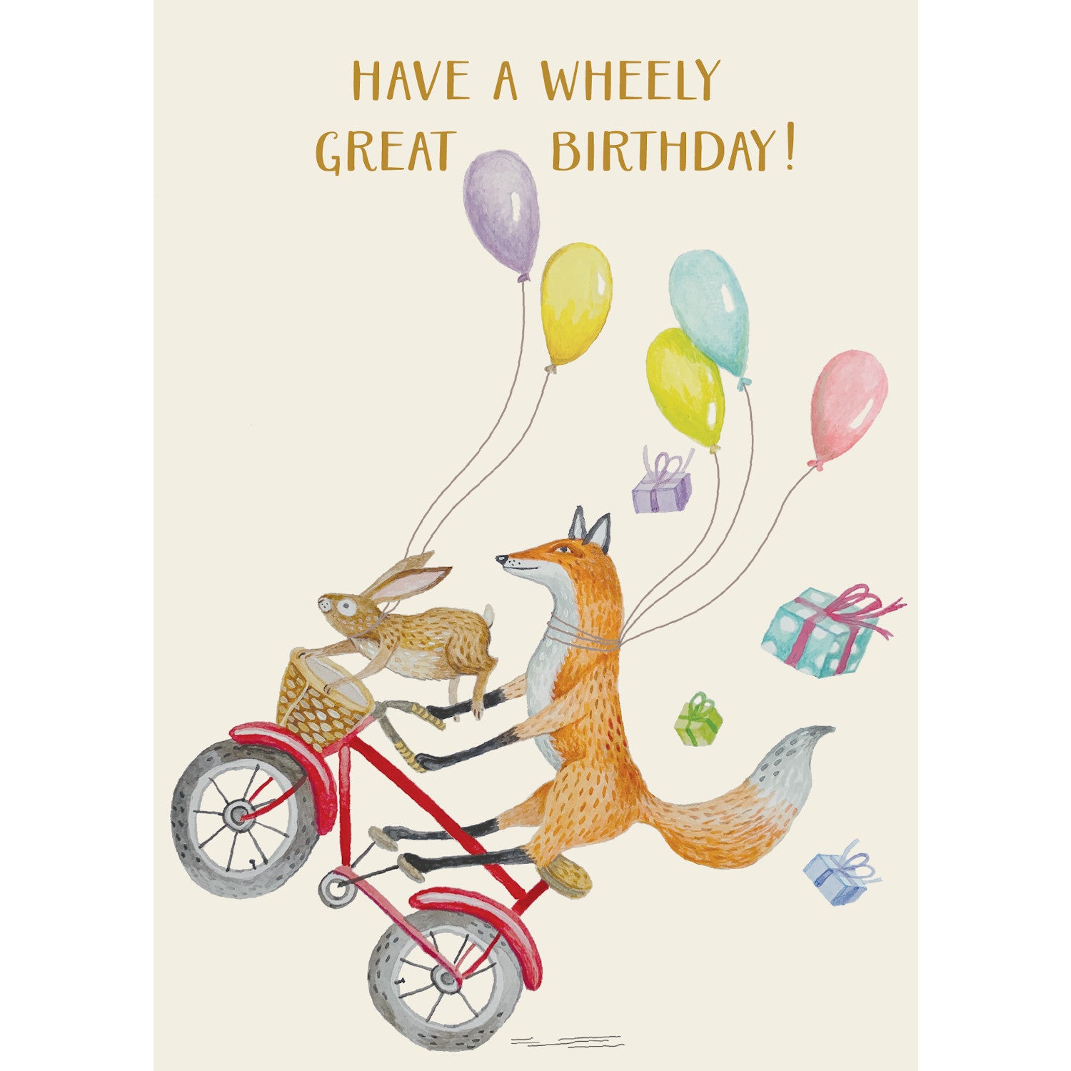 A whimsical illustration of a fox popping a wheely on a red bicycle with a rabbit hanging on to the basket, trailing with colorful balloons and wrapped gifts flying behind them, and the message &quot;HAVE A WHEELY GREAT BIRTHDAY!&quot; printed in gold across the top of the card.
