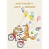 A whimsical illustration of a fox popping a wheely on a red bicycle with a rabbit hanging on to the basket, trailing with colorful balloons and wrapped gifts flying behind them, and the message "HAVE A WHEELY GREAT BIRTHDAY!" printed in gold across the top of the card.