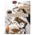 A top-down photo of a loaf of artisanal bread on a cutting board with a bowl of salt, next to a bottle and two glasses of red wine resting on a white tablecloth, with a new home blessing printed over the image.
