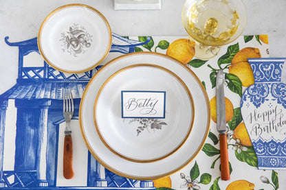 A tablescape with an elegant touch, featuring Die-cut Pagoda Placemats by Hester &amp; Cook and lemons as accents.