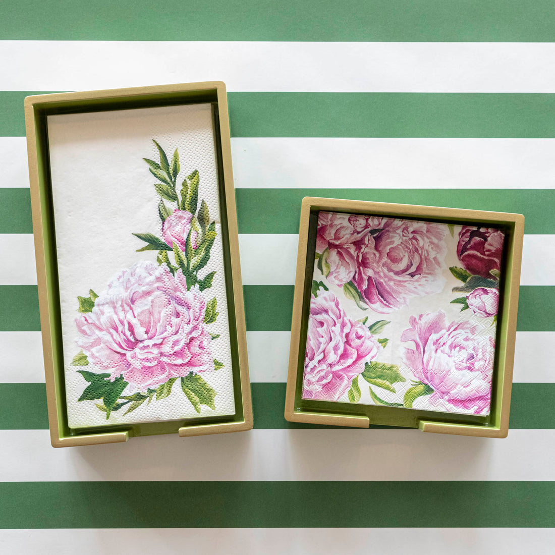 Two gold napkin holders full of Peony Guest Napkins and Peony Cocktail Napkins.