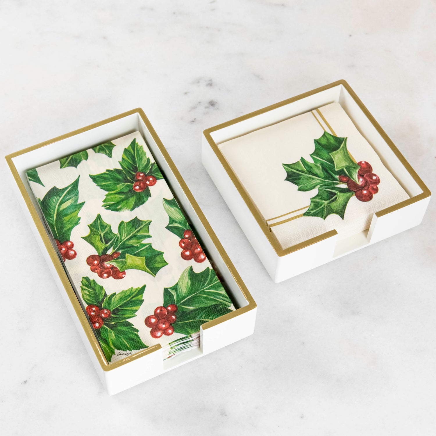 A lacquered wood holder for beverage and guest napkins, featuring a white color with gold trim and a napkin inside.