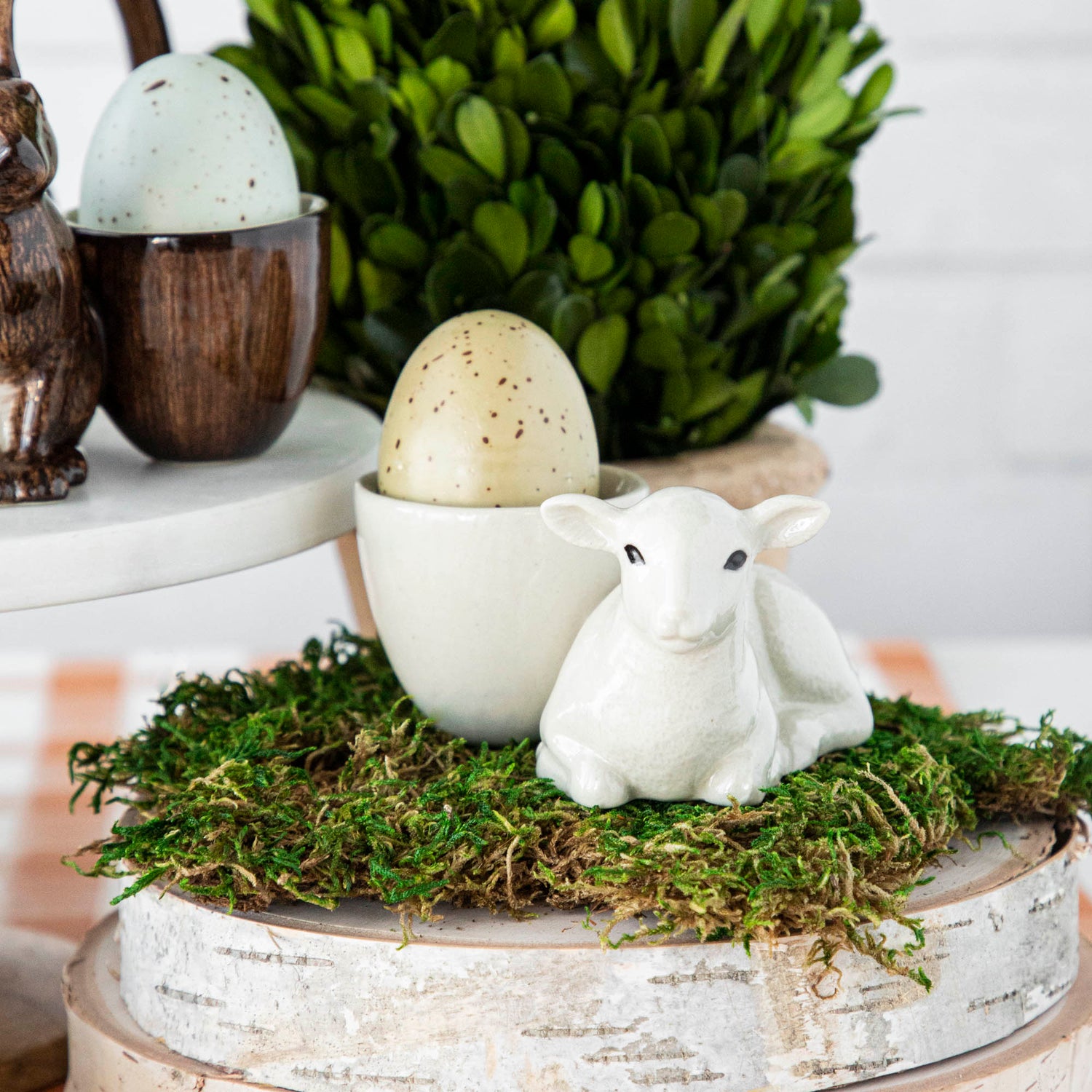 Add a touch of whimsy to your Easter table with quirky Farm Animal Ceramics from Quail. This British brand offers charming sheep figurines, vibrant eggs, and lush moss for a festive centerpiece.