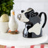 A quirky Farm Animal Ceramics cow jug from the Quail brand sits on a table.