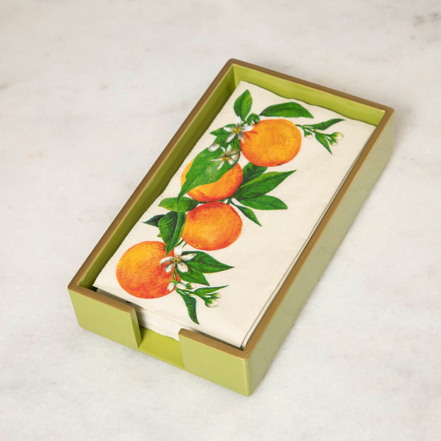 A green lacquered wood beverage napkin caddy with gold trim, featuring a napkin  with an orange pattern.