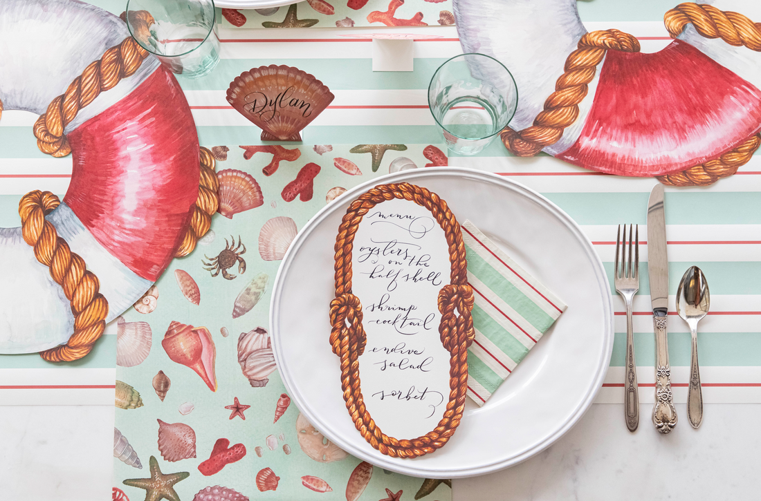 A table setting with Seafoam &amp; Red Awning Stripe Runner and seashells, perfect for entertaining. (Brand: Hester &amp; Cook)