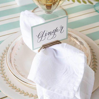 The Seafoam &amp; Gold Awning Stripe Runner under an elegant place setting.