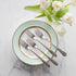 Elegant table setting with mint green plates, Hester & Cook vintage silver-plate long handled salad fork set of four, and white tulips on a marble surface.