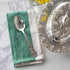 A Hester & Cook vintage silver-plate serving spoon sits on top of a green napkin.