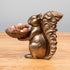 A bronze Accent Decor squirrel holding a bowl of nuts.