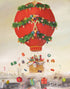 A whimsical painting by Janet Hill, "The Peppermint Family Christmas Balloon Ride Small Art Print" of a red hot air balloon decorated like a Christmas tree, floating over a cityscape, with gifts and ornaments suspended in the air around it.