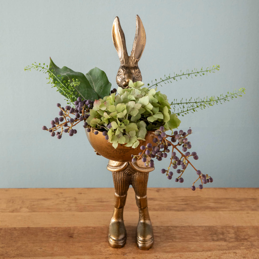 A well-dressed Accent Decor gold Hare Dishstand holding a basket of flowers.