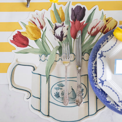 A colorful table setting with Hester &amp; Cook Die-cut Tulip Teapot Placemats, a vase of tulips and silverware.