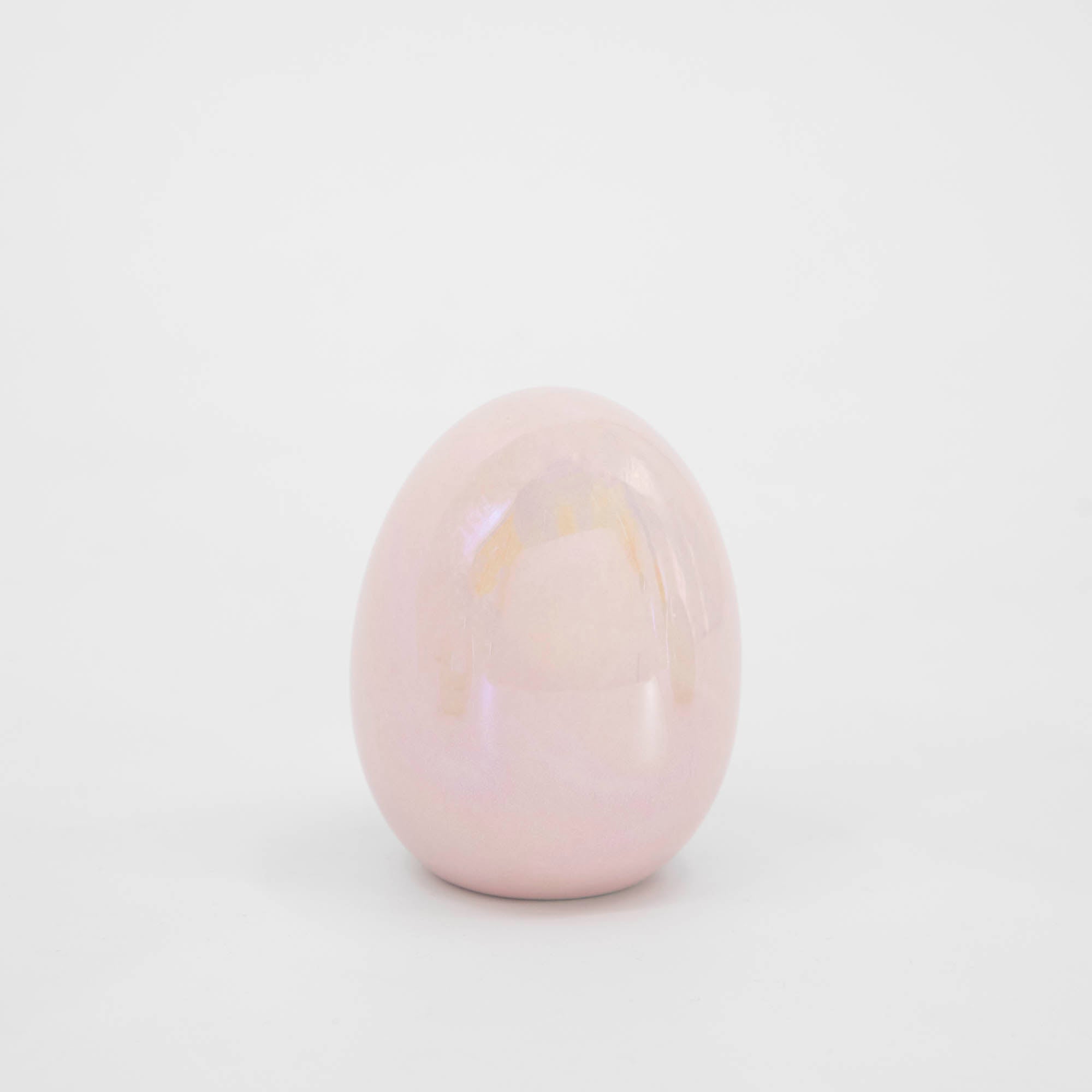 A Small Iridescent Easter egg sitting on a white surface. (Brand Name: Glitterville)