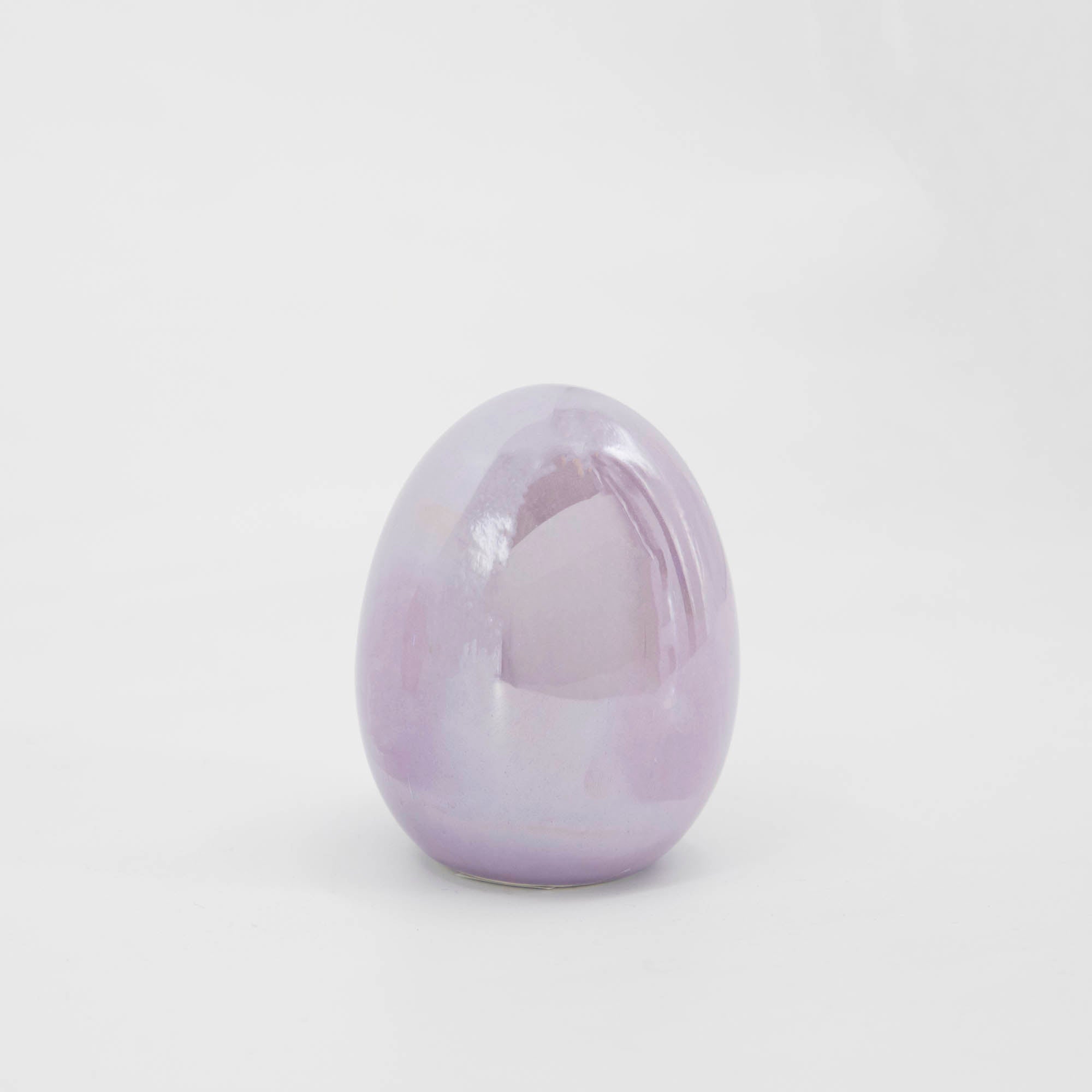 A small Glitterville iridescent egg sitting on a white surface.