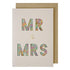 A Meri Meri Mr & Mrs Card With Confetti featuring "mr & mrs" cut out in pastel floral print against a white background and adorned with gold foil.