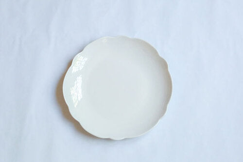 A sweet Scallop Cream Dinner Plate by Relish Dinnerware on a white surface.