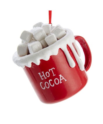 A red ceramic hot cocoa cup with white marshmallows spilling out, with &