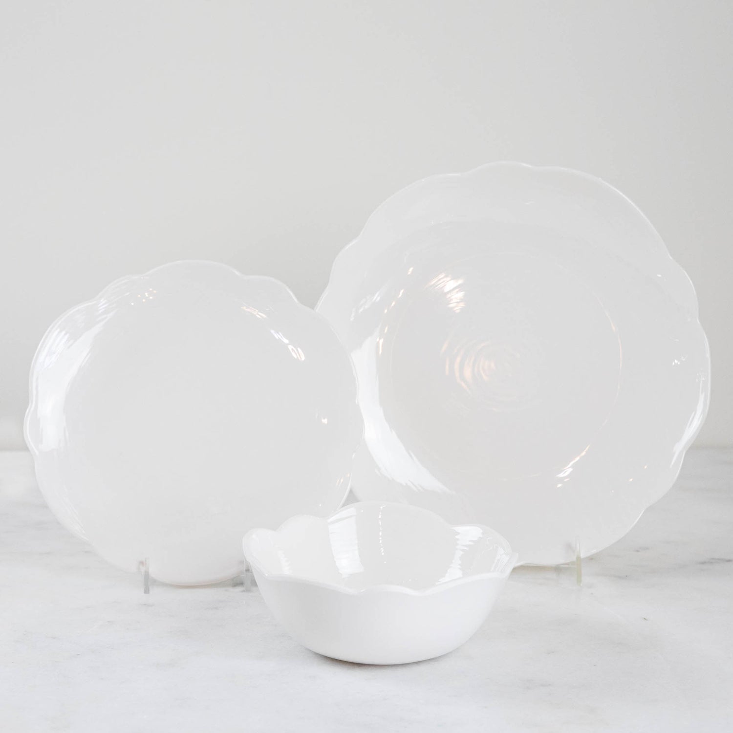 A set of Scallop Cream Dinner Plates by Relish Dinnerware on a marble table.