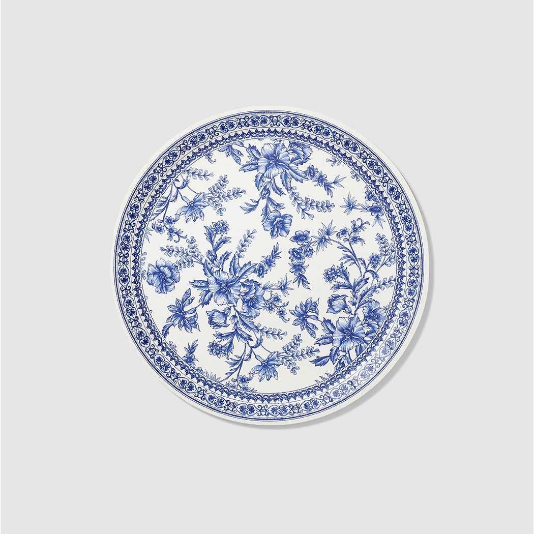 A Blue French Toile Paper Party Dinnerware plate with floral designs, inspired by the French countryside. This elegant piece of Blue French Toile Paper Party Dinnerware from Coterie Party Supplies is adorned with intricate blue patterns.