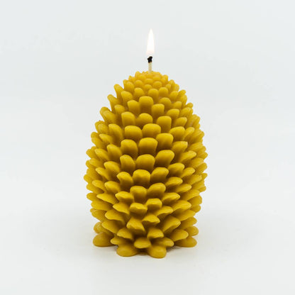 A large Beeswax Pine Cone Candle lit.