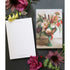 The "Lost at Sea" Tear-Away Notepad resting on a table with flowers, next to a single removed sheet flipped over to show the blank white back side labeled "Notes" at the top. The artwork is a painterly illustration of a bouquet of flowers and botanicals in an asymmetrical teal vase with an orange seahorse on the base, resting on a beige table.