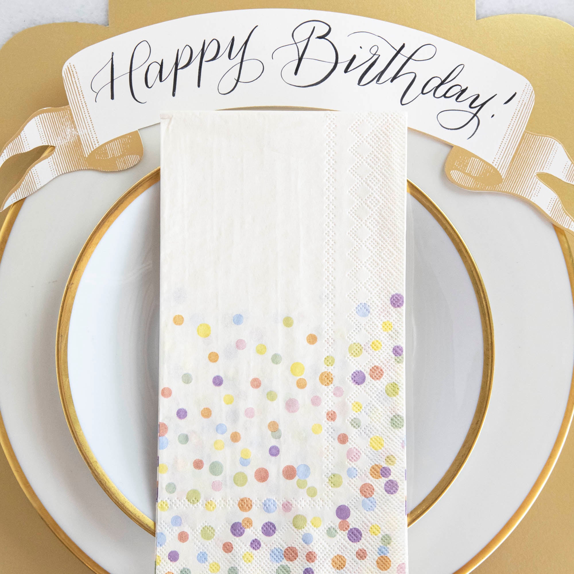 A gold plate with Confetti Sprinkles Napkins by Hester &amp; Cook for birthdays.