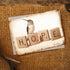 A "Hope" (Scrabble) notecard with a hummingbird illustration and the word "hope" spelled out with letter tiles rests on a woven surface. (David Arms)