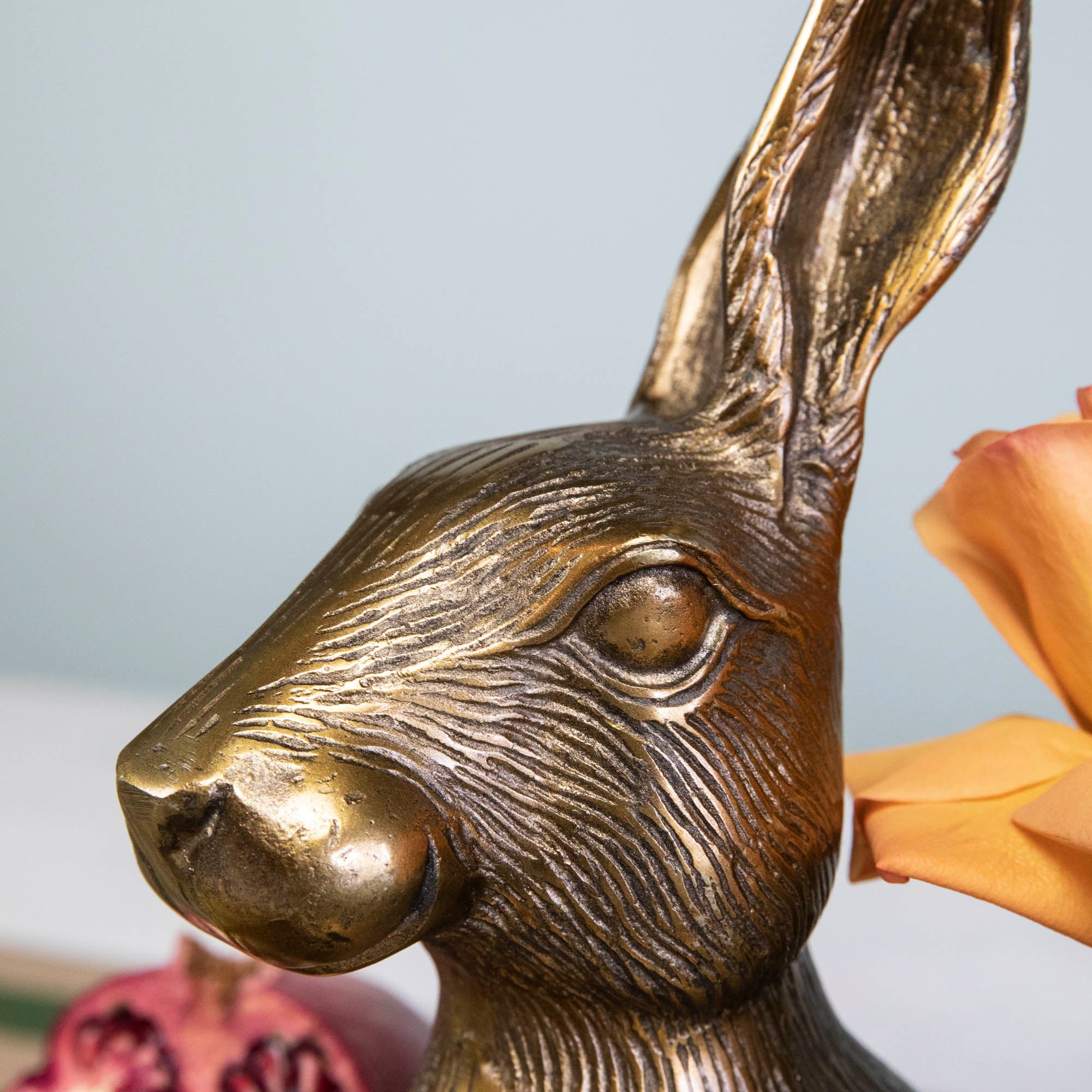 An Accent Decor Hare Platter sits on a table next to flowers.