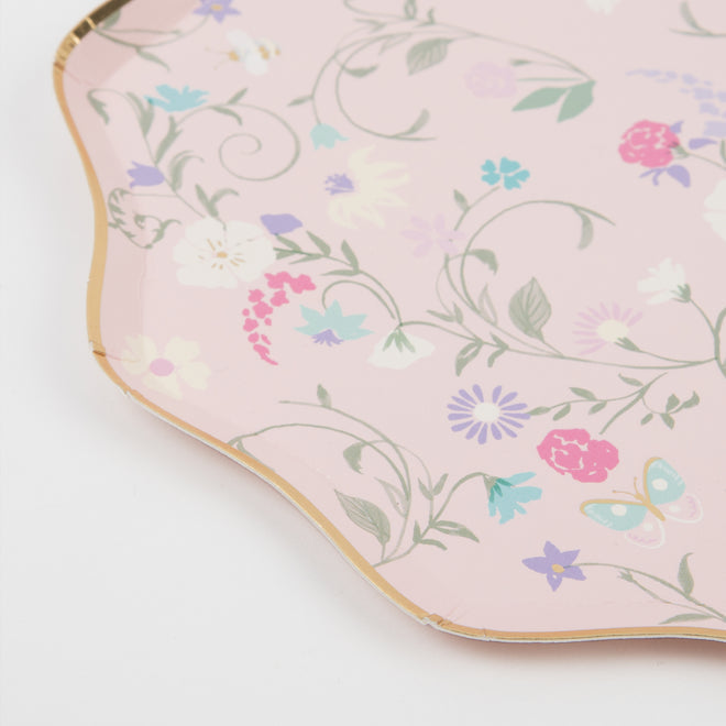 A pink Ladurée Paris Floral Side Plate by Meri Meri with a floral design of flowers and butterflies on it.