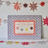 A craft kit titled "Make a Star Garland" by Cambridge Imprint displayed on a shelf with FSC-certified card, star decorations around.