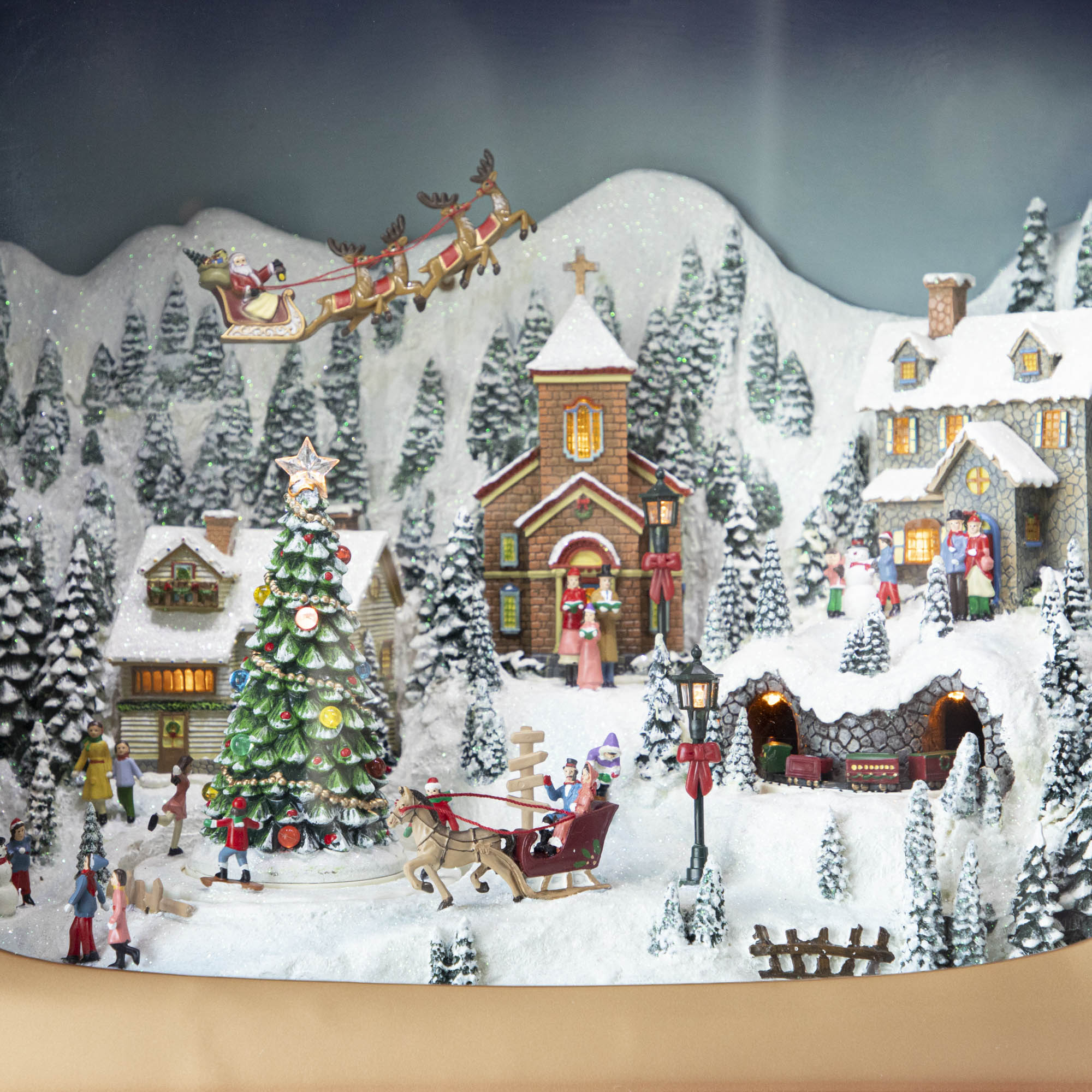 A close up of the Retro Animated TV scene showing a winter village with Christmas festivities and Santa and his reindeer flying above the town.