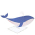 A paper craft of a blue whale with a spout, designed as a stand-up greeting card featuring iridescent and silver foil detail, the Whale Stand Up Card by Meri Meri.
